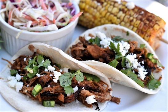 Crock pot pork carnitas tacos with grilled Mexican corn and coleslaw. 